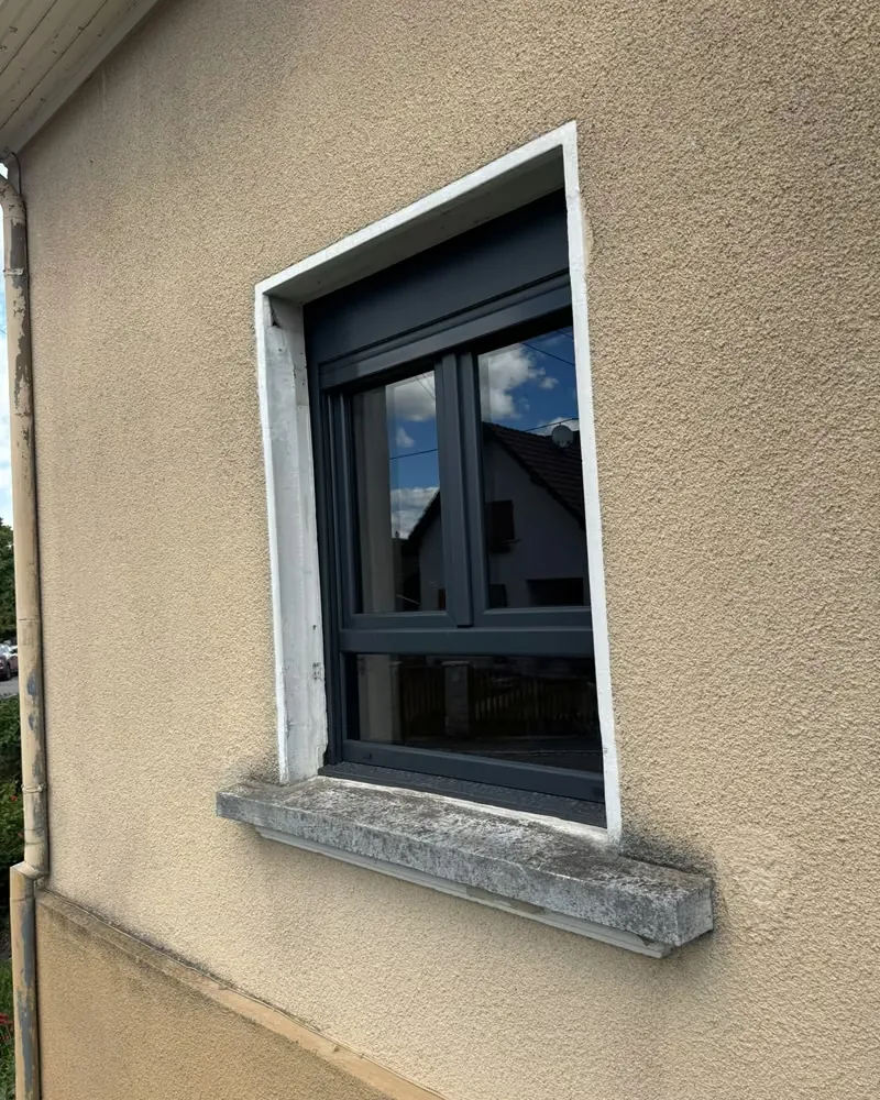 La même fenêtre anthracite vue de biais, après la pose — photo de chantier
