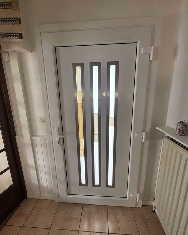 Porte d’entrée blanche à trois bandes vitrées verticales, vue de l’intérieur — photo de chantier